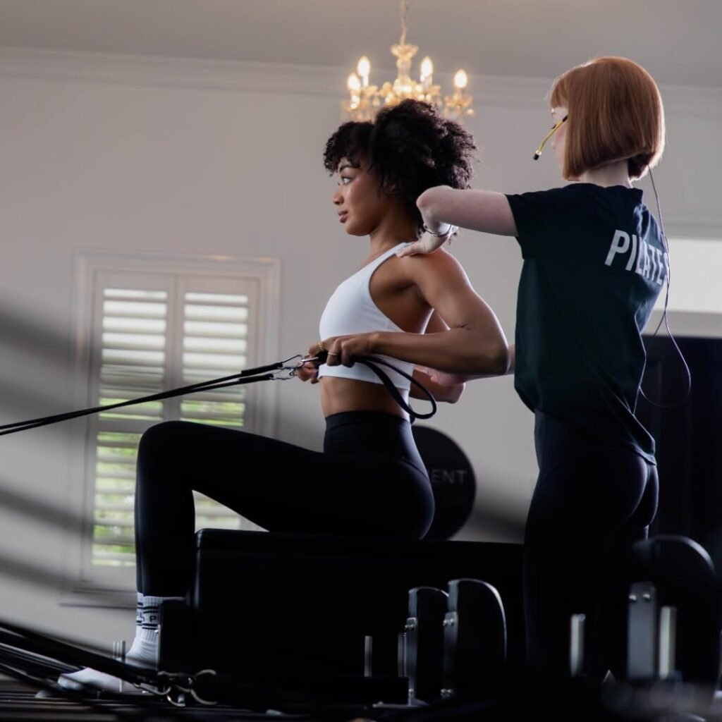 Instructor guiding a small group Reformer Pilates class
