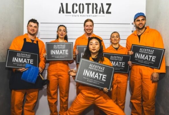 Group of friends posing in jumpsuits inside Alcotraz Surfers Paradise cell block