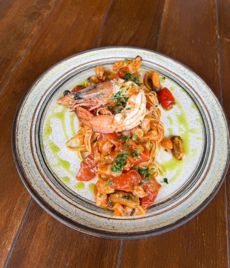 Linguine with prawns, mussels, cherry tomato sauce and jumbo prawns, finished with parsley oil