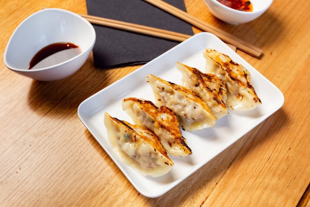 Close-up of a crispy grilled gyoza with dipping sauce
